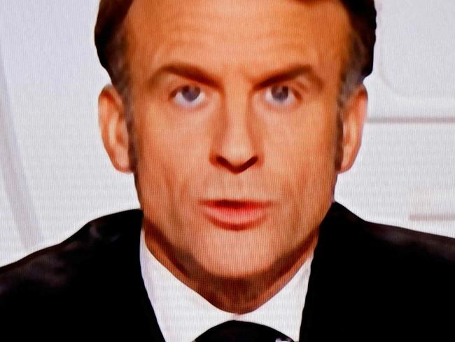 This photograph taken on March 5, 2025, shows a television screen broadcasting France's President Emmanuel Macron addressing a live interview on French TV at the Elysee Presidential Palace in Paris. Emmanuel Macron announced on March 5, 2025, that France will gather next week in Paris the chiefs of staff from countries ready to guarantee a future peace in Ukraine. (Photo by Ludovic MARIN / AFP)