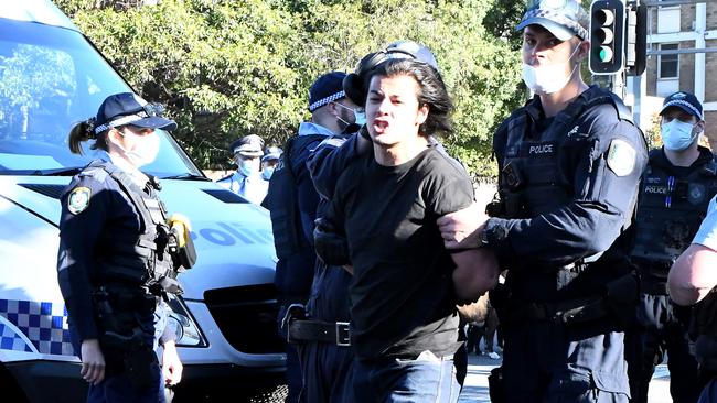 An anti-lockdown protester is detained in Sydney.