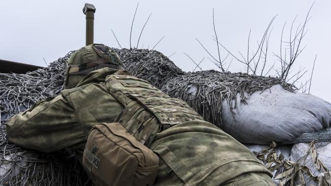 A Ukrainian soldier uses a hand-held periscope to view the positions of Russian forces in Zolote, Ukraine. Picture: Getty Images.