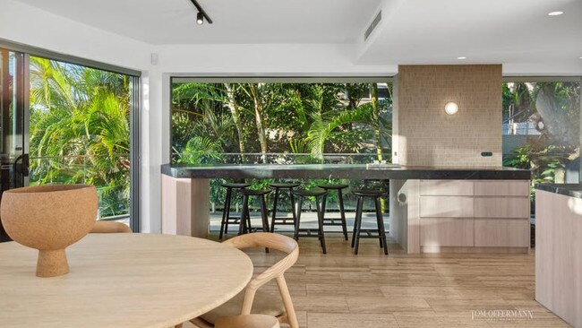 The home is backed by greenery with views of the ocean out front.