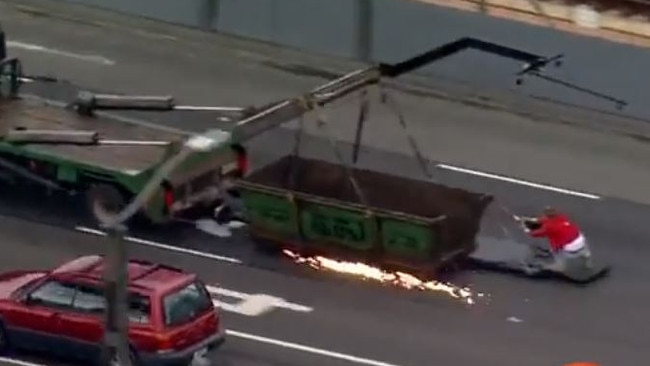 The actor – or his stunt double – was seen hanging off the back of a truck by a shovel.