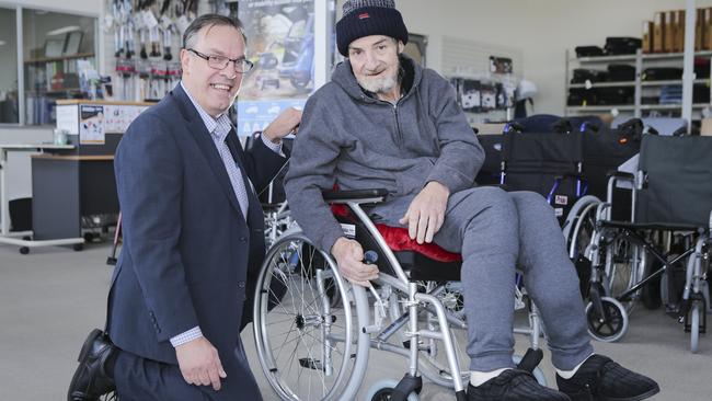 Greg Hehir gets a new wheelchair courtesy of Eugene Pizzolato from Mobility Aids Australia, after his was destroyed in a house fire. Picture: Wayne Taylor.