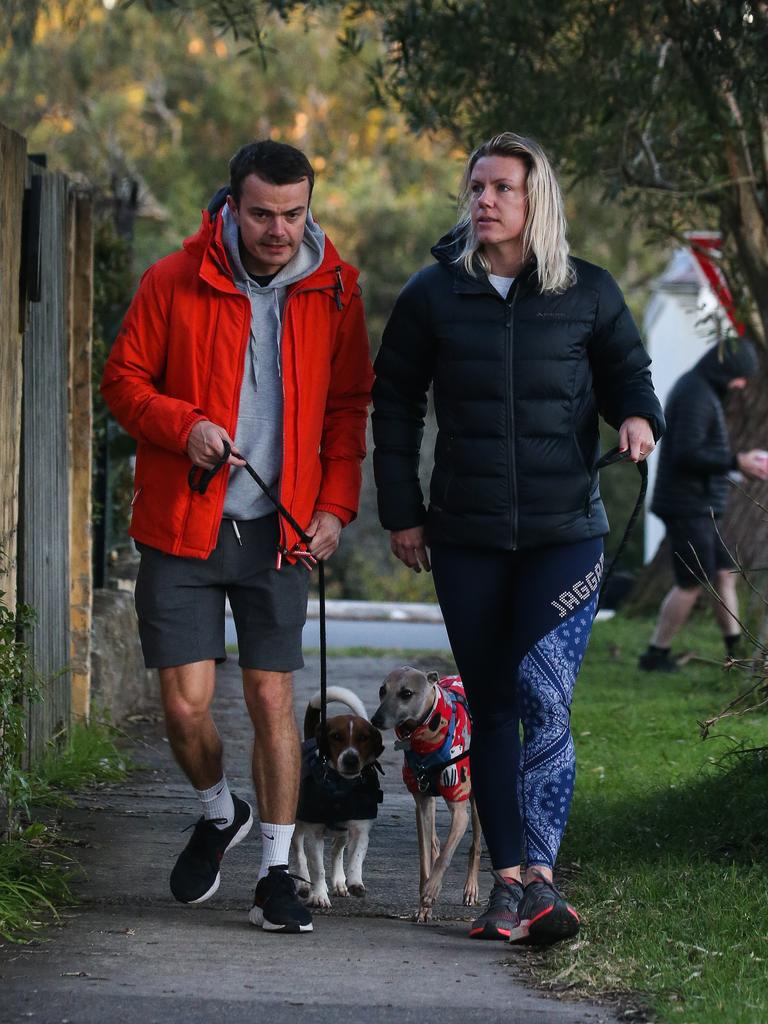 Shane Conaghan and Bianca Dewit rug their pets up in fleecy winter warmers during an early-morning walk. Picture NCA NewsWire/ Gaye Gerard