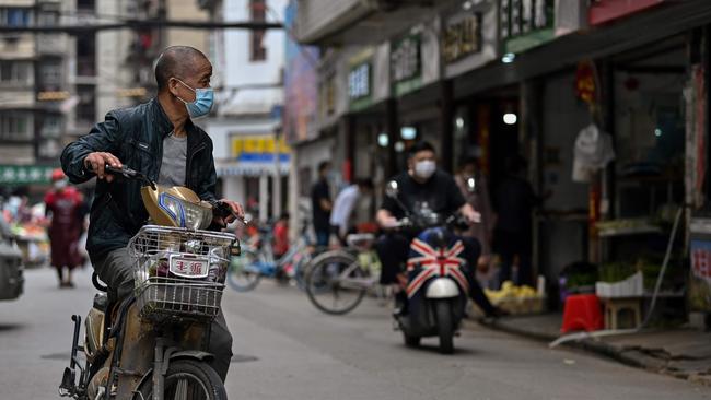 Scooter riders at a market in Wuhan, in China’s central Hubei province. Picture: Hector Retamal/AFP