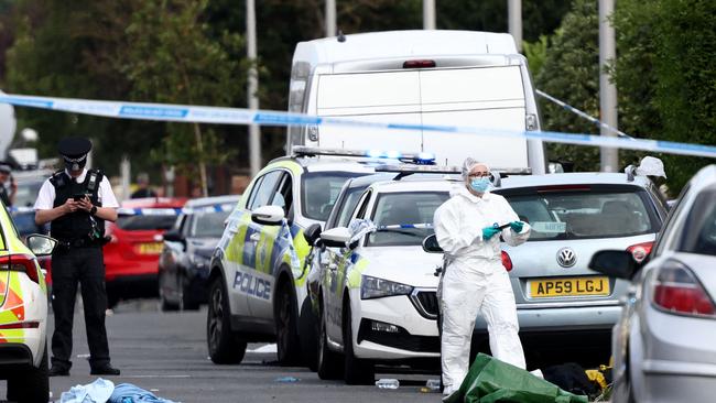 (FILES) Police officers and forensic personnel stand behind a cordon on Hart Street in Southport, northwest England, on July 29, 2024, following the knife attack. (Photo by Darren Staples / AFP)