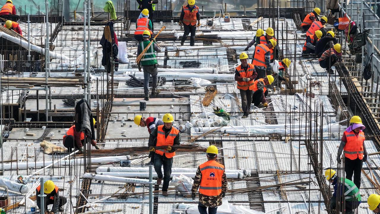 Workers on a rooftop of a residential building under construction in Nanjing, in eastern China. Beijing is targeting growth of “about 5 per cent” this year. Photo: AFP