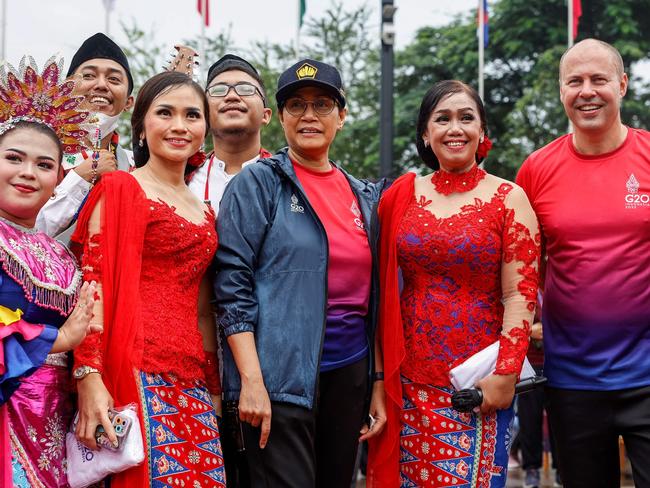 Indonesiaâs Finance Minister Sri Mulyani (C-L) and Australiaâs Treasurer Josh Frydenberg (C-R) pose for photographs with traditional musicians and dancers during a social event of the G20 finance ministers and central bank governors meeting in Jakarta on February 18, 2022. (Photo by Mast IRHAM / POOL / AFP)