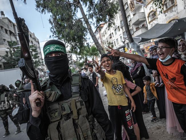 GAZA CITY, GAZA - MAY 22: Fighters of Ezz al-Din Al-Qassam brigades, the military wing of Hamas, march in greeting to the Al Qassam commanders in Gaza Basim Issa in Gaza City on May 22, 2021 in Gaza City, Gaza. The ceasefire between Israel and Hamas appeared to be holding, despite fresh clashes at Al-Aqsa Mosque in East Jerusalem. The ceasefire brings to an end eleven days of fighting which killed more than 250 Palestinians, many of them women and children, and 13 Israelis. The conflict began on May 10th after rising tensions in East Jerusalem and clashes at the Al Aqsa Mosque compound. (Photo by Fatima Shbair/Getty Images)