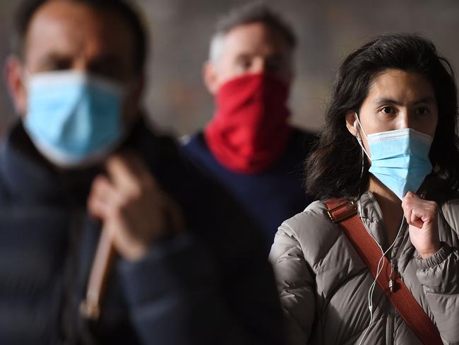 Commuters walk past Melbourne's Flinders Street Station on July 23, 2020 on the first day of the mandatory wearing of face masks in public areas as the city experiences an outbreak of the COVID-19 coronavirus. (Photo by William WEST / AFP)