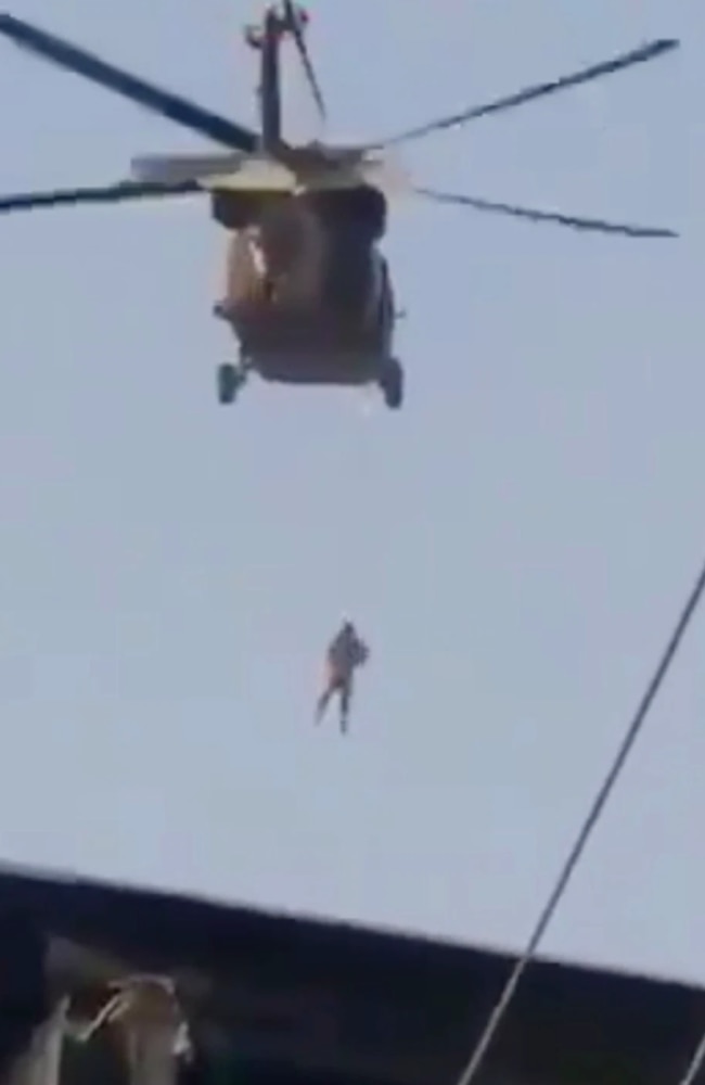 Shocking footage posted on Twitter shows a person strung by rope hanging from a Black Hawk helicopter allegedly being flown by Taliban members. Picture: Twitter