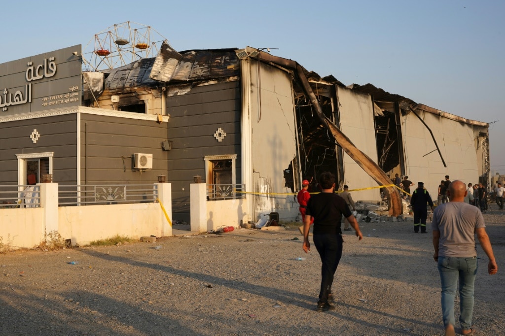 Iraqis walk past the scene of the tragedy in the predominantly Christian town of Qaraqosh, also known as Hamdaniyah