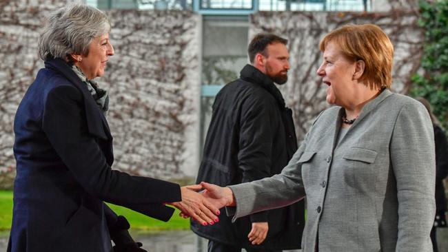 Theresa May reaches out to German Chancellor Angela Merkel in Berlin last night as she seeks ‘assurances’ from European leaders on her Brexit deal.