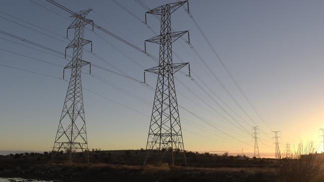 Power lines hang from transmission towers on Torrens Island, South Australia, on Monday, April 2, 2018. A plan byÃÂ Tesla Inc.ÃÂ to build the world's largest virtual power plant may be in jeopardy after the South Australian political party that championed the deal was ousted from government, setting up a potential retreat from ambitious renewableÃÂ energyÃÂ targets. Photographer: Carla Gottgens/Bloomberg via Getty Images