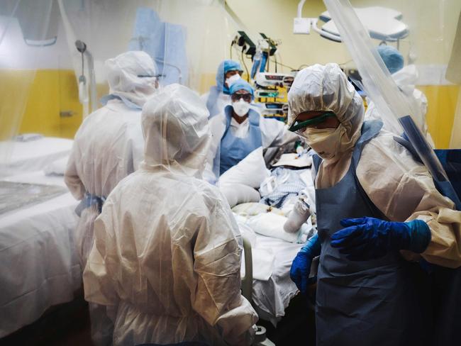 TOPSHOT - Medical staff members take care of a patient infected with COVID-19 at the intensive care unit of the Franco-Britannique hospital in Levallois-Perret, northern Paris, on April 9, 2020. (Photo by LUCAS BARIOULET / AFP)