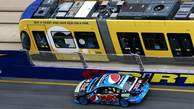 Pepsi Max Crew's Mark Winterbottom races the G:link tram during race 1 of the V8 Supercars  at the GC600 on Saturday.  Picture: Jerad Williams