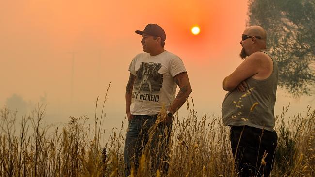 Locals watch the bushfire as it threatened houses.