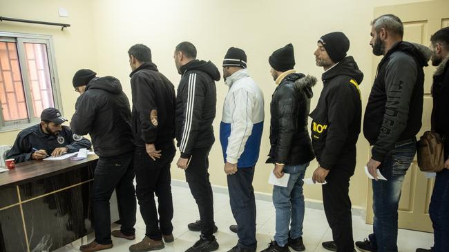 Men wait to give their details at a reconciliation centre in Latakia - giving former conscripts of the Assad regime a chance to clear their names of any wrongdoing and to gain new IDs. Picture: Getty