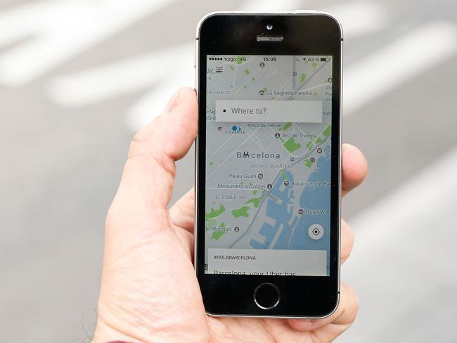 A phone displays the Uber app in Barcelona on March 13, 2018. Uber said it was back in Barcelona with 120 professional drivers after it was forced out three years ago over the suspension of its service that enables unregulated drivers to ferry passengers for money using their own cars. / AFP PHOTO / PAU BARRENA