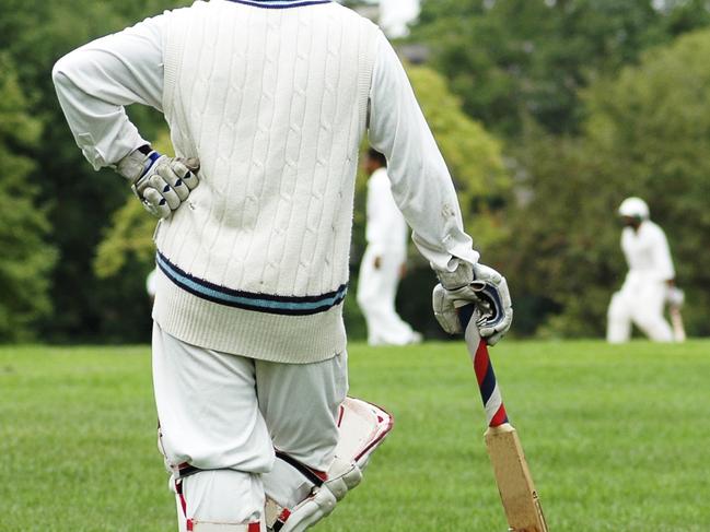 Cricket player waiting, leaning on the bat.  - Picture istock