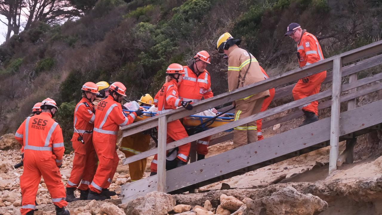 Emergency crews work to free and transport a woman who become stuck in rocks at Torquay between Cosy Corner and Fishermans Beach. Pictures: Shaun Viljoen