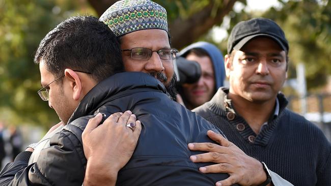 Imam Mohammad Ramzan is comforted in front his burnt mosque. Picture: Nicole Garmston