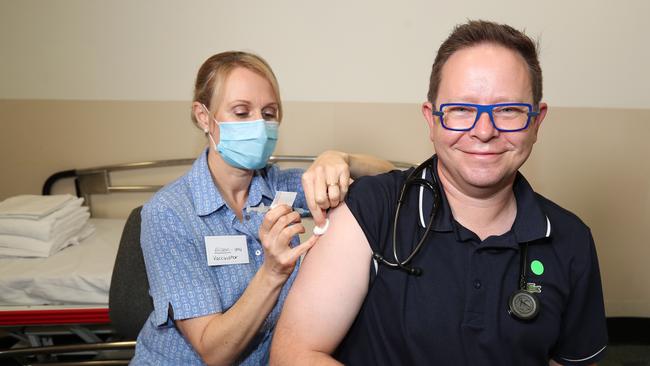 Nurse Alison Clancy injects Mater Health Services infectious disease physician Associate Professor Paul Griffin with the AstraZeneca COVID-19 vaccine. Photo: Annette Dew.