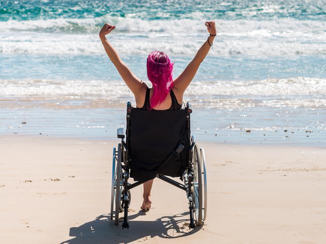 Disabled woman in the wheelchair at the beach