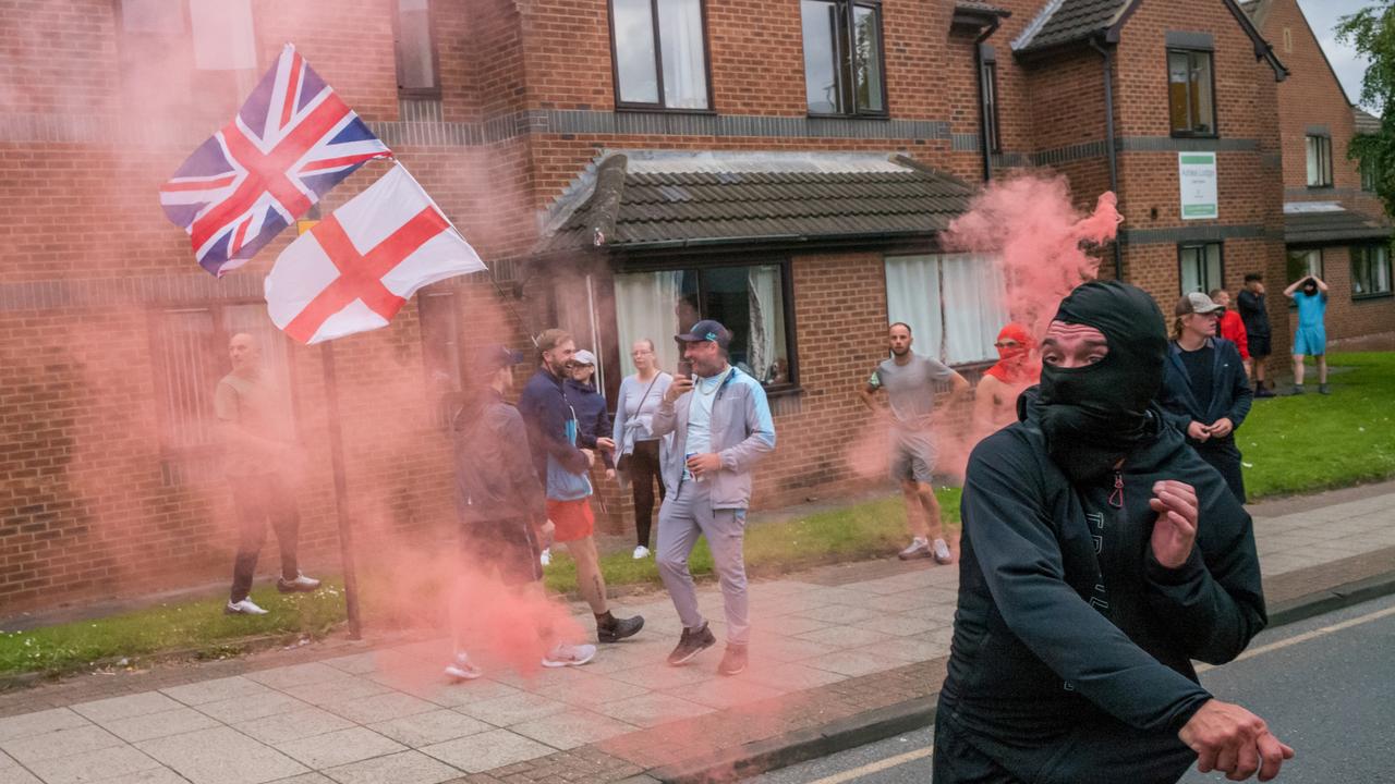 A demonstrator throws a smoke flare at police as activists hold an Enough is Enough protest in Sunderland. Picture: Getty Images