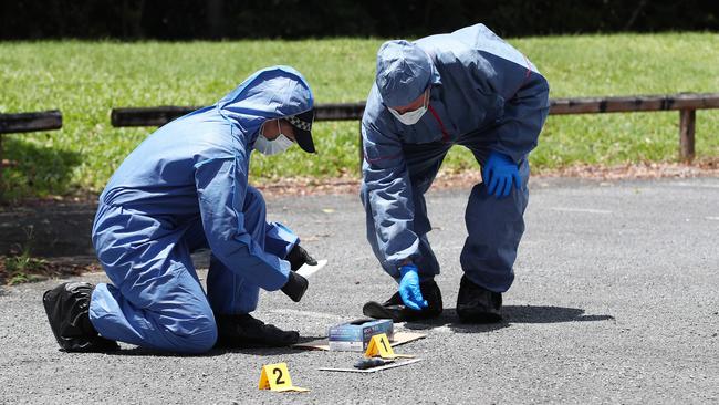 Cairns police scientific officer Sgt Vanessa Lobegeier and Scenes of Crime officer Acting Sgt Wayne Boniface swab a knife, potential evidence in a simulated crime scene training exercise set up at Pezzutti Park, Woree. Picture: Brendan Radke