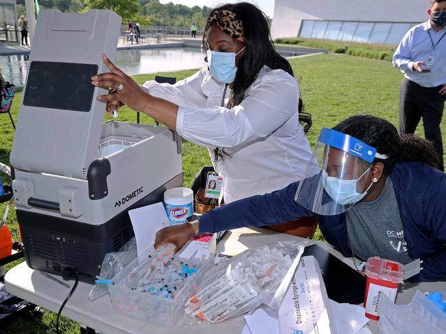 A nurse pulls a vial of the Johnson &amp; Johnson vaccine from a portable refrigerator as at a walk-up clinic in Washington this week. Picture: Getty