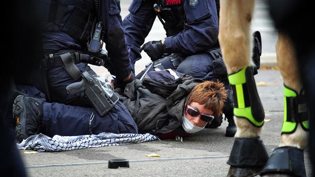 A protester is held down by police outside the Victorian Parliament. Picture: NCA NewsWire / Luis Enrique Ascui