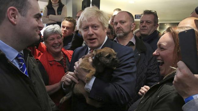 Boris Johnson meets a supporter's dog at Sedgefield Cricket Club in County Durham, northeast England. Picture: AP