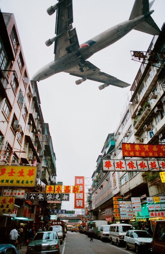 Here a plane screeches past apartment blocks of Kowloon city as it approaches Kai Tak Airport – shaving past a forest of TV antennas – a day before the airport closed in 1998. Picture: Tommy Cheng / AFP