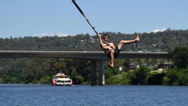 Koby Matthews jumps into the Nepean River to cool off at Penrith in Sydney on Friday. Picture: NCA NewsWire/Joel Carrett