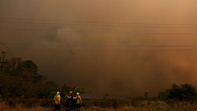 NSW Rural Fire Service and Fire and Rescue NSW firefighters watch on as the Gospers Mountain bushfire approaches Kurrajong Heights on December 21, 2019. (AAP Image/Dan Himbrechts)