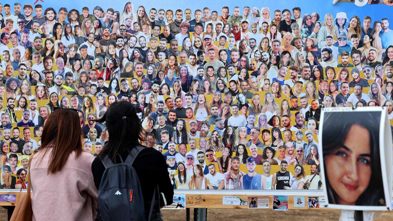 Israelis visit a memorial bearing portraits of people taken hostage or killed in the Hamas attack on the Supernova music festival on October 7 at the site of the festival near Kibbutz Reim in southern Israel. Picture: Jack Guez / AFP