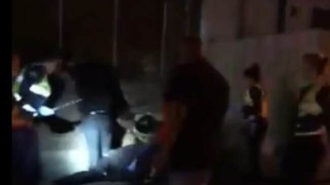 A screengrab from a video posted to Facebook show police using batons.