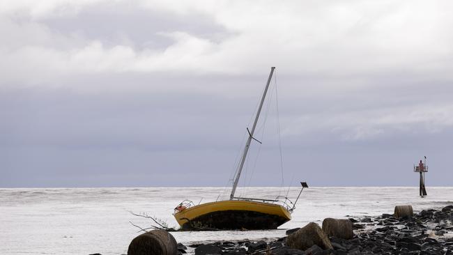 A Yacht and silage bales washed up at the mouth of the Mersey River. Picture: Grant Viney