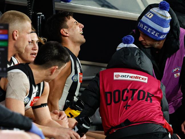 MELBOURNE, AUSTRALIA - JUNE 10: Nick Daicos of the Magpies is assessed by medical staff on the bench during the 2024 AFL Round 13 match between the Collingwood Magpies and the Melbourne Demons at The Melbourne Cricket Ground on June 10, 2024 in Melbourne, Australia. (Photo by Dylan Burns/AFL Photos via Getty Images)