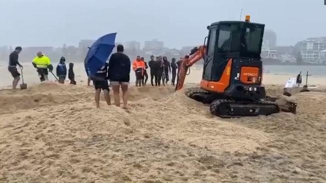 Ben Weber, of Chittaway Bay, took an excavator onto North Entrance Beach to help hundreds of people unblock The Entrance Channel during torrential rain during February floods.