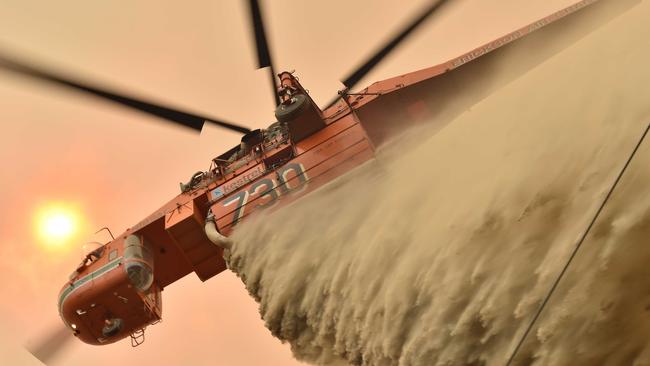 A photo from November 19, 2019 shows a helicopter dropping fire retardant to protect a property in Balmoral, 150 kilometres southwest of Sydney. Picture: AFP