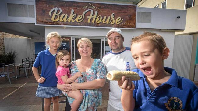 Jake Peterie (front) gets into one his family's sausage rolls from The Bake House Yamba, with Laura, Sophia, Kylie and Mathew Peterie. Picture: Adam Hourigan