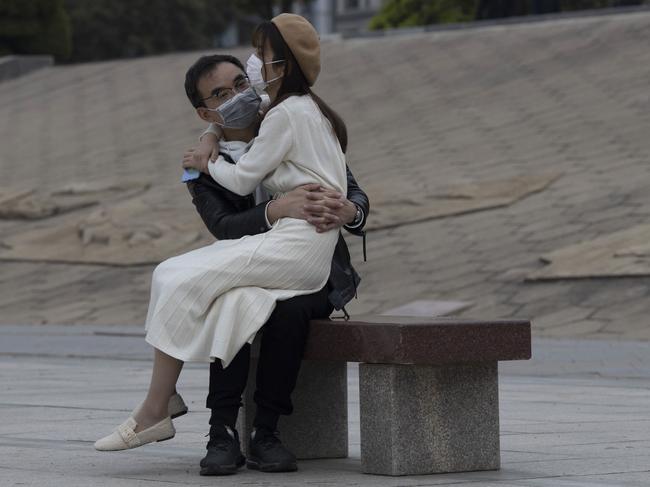 A couple sits together on a bench in the Chinese city of Wuhan. Picture: AP