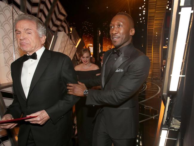 Warren Beatty tightly grips the award envelope as he leaves the stage with Moonlight star Mahershala Ali. Picture: Christopher Polk/Getty Images/AFP