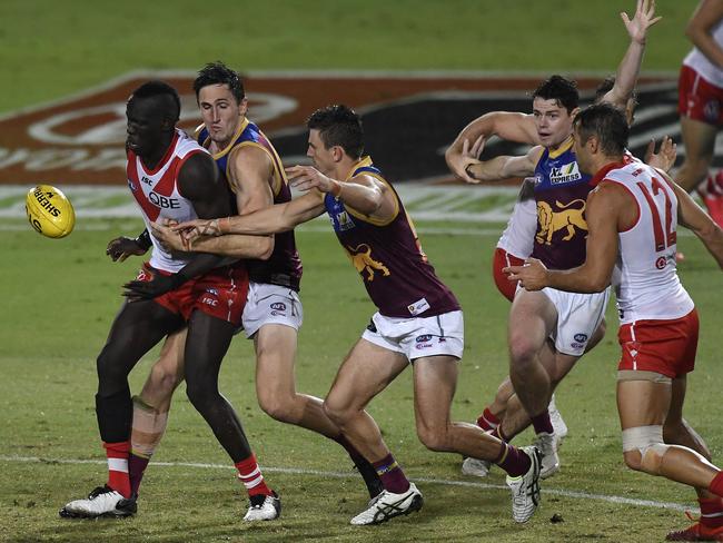 The off-the-ball attention to Brisbane midfield machine Lachie Neale (right) goes unnoticed as Sydney’s Aliir Aliir is tackled. Picture: Getty Images