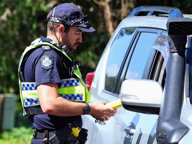 Cairns police have begun National Road Safety Week with a safety blitz. A Queensland Police traffic officer performs a random breath test on the Captain Cook Highway at Aeroglen. Picture: Brendan Radke