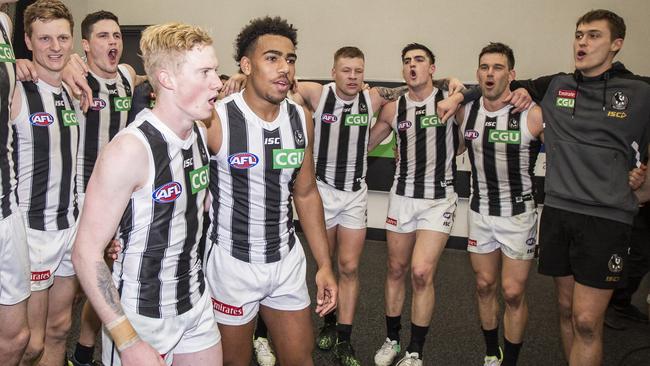 The Pies encircle young Pies John Noble and Isaac Quaynor after their first victory in black and white. Picture: AAP