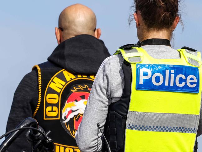 A Comanchero Motorcycle Club  member has his colours photographed by police at the United Petrol Station in  Tooradin. Picture : Ian Currie