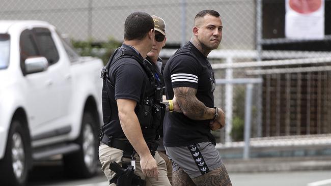 Harley Barbaro being escorted by police into the Southport Watchhouse on Friday.