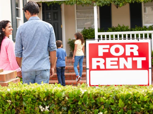 Hispanic family outside home for rent holding hands looking at each other happy